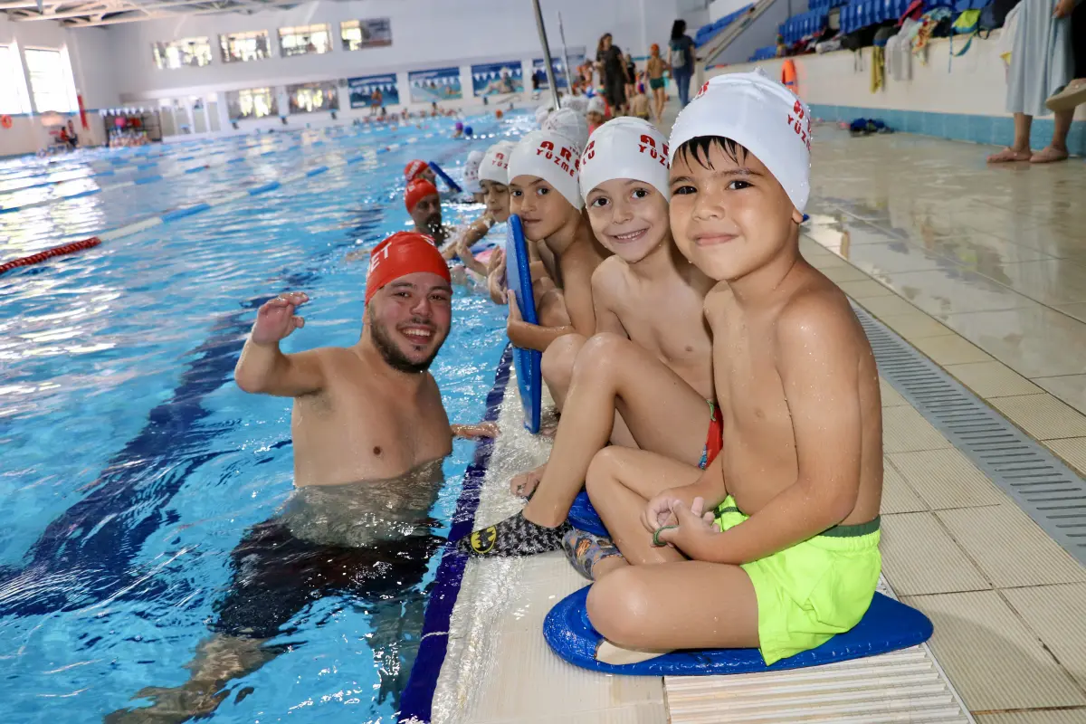 Ortopedik engelli antrenör çocuklara yüzme öğretiyor